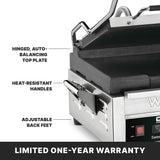 A close-up of a stainless steel panini press with its lid partially open. Labeled features include flat cast iron plates, a hinged auto-balancing top plate, heat-resistant handles, and adjustable back feet. “LIMITED ONE-YEAR WARRANTY” appears at the bottom.
