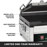 Close-up of a stainless steel toasting grill with flat cast iron plates, showing labels for its hinged, auto-balancing top plate, heat-resistant handles, adjustable back feet, and control panel with switch. Text at the bottom reads LIMITED ONE-YEAR WARRANTY.