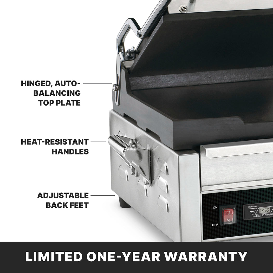 A close-up of a stainless steel dual toasting grill with labels highlighting its hinged, auto-balancing top plate, flat cast iron plates, heat-resistant handles, and adjustable back feet. The text at the bottom reads “LIMITED ONE-YEAR WARRANTY.”.