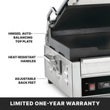A close-up of a stainless steel dual toasting grill with labels highlighting its hinged, auto-balancing top plate, flat cast iron plates, heat-resistant handles, and adjustable back feet. The text at the bottom reads “LIMITED ONE-YEAR WARRANTY.”.
