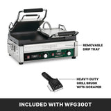 A Waring dual toasting grill with raised top plate, flat cast iron plates, and labeled removable drip tray. Below, a black heavy-duty grill brush with scraper. Text reads: INCLUDED WITH WFG300T on a black background.