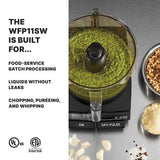 A 2.5 quart commercial food processor filled with green pesto sits on a stainless steel counter. Chopped nuts and garlic are nearby. Text on the left reads: The WFP11SW’s LiquiLock Seal System is built for no-leak batch processing, chopping, and puréeing.
