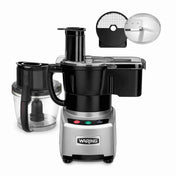 A silver and black Waring combination food processor with a clear mixing bowl, handle, and lid. Three buttons—red, green, and black—are on the base. A slicing disc and grid attachment appear separately in the upper right corner.