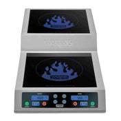 A stainless steel double induction range cooktop with digital displays, touch controls, and blue flame graphics on each black burner, labeled “WARING COMMERCIAL.” The countertop unit features a control panel with buttons and separate burner displays.