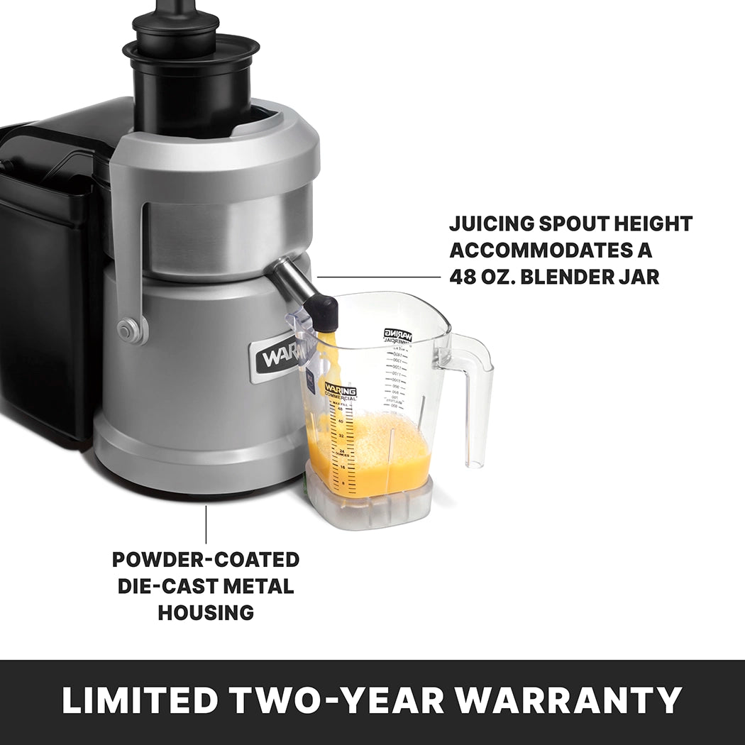 A silver and black heavy duty juice extractor with a tall spout is dispensing orange juice into a clear measuring pitcher. Text points to the spout, noting it fits a 48 oz. blender jar, and highlights continuous pulp ejection. Limited Two-Year Warranty.