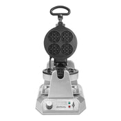 A heavy duty stainless steel waffle maker with non-stick plates features a round, four-section waffle plate. It has a top handle, control dial, indicator lights, and the “Waring” label on its modern metallic base.