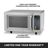 A stainless steel microwave oven with a digital keypad, handle, display showing 2:30, and text noting medium duty 1000 watts power, HEAVY-DUTY BRUSHED STAINLESS STEEL CONSTRUCTION, 0.9 CUBIC FEET INTERIOR SPACE, and LIMITED ONE-YEAR WARRANTY at the bottom.