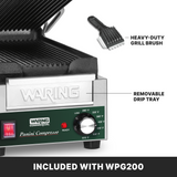 A Waring Panini grill is shown with labeled removable drip tray, ribbed cast iron plates, and a heavy-duty grill brush above it. The adjustable thermostat dial is visible, with text below reading, “INCLUDED WITH WPG200.”.