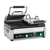 A stainless steel Waring WPG300T dual panini grill with a hinged, ridged top plate lifted open, revealing black grill plates. The front features control knobs, switches, indicator lights, and a green label reading Panini Ottimo.