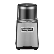 A stainless steel Waring WSG60KSDI Commercial Spice Grinder with a clear plastic top, labeled “Waring” on the front. The brushed metal finish and lock/unlock symbols beneath the transparent lid make it ideal for international use.