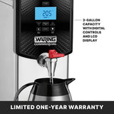 A stainless steel Hot Water Dispenser sits on a countertop, featuring a digital LCD display reading 2:05. The red spigot fills a metal carafe, while text highlights its 3-gallon capacity, digital controls, and LCD display. Banner: LIMITED ONE-YEAR WARRANTY.
