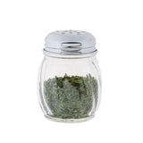 A clear polycarbonate shaker filled with dried green herbs, topped with a shiny metal lid featuring small holes. The BPA free jar is isolated on a white background.