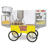 A yellow popcorn cart labeled “Caramel Corn” with four black-and-white wheels displays caramel corn, regular popcorn, and jars of caramel corn. On top sit a PopMaxx Popper, silver popcorn machines, and a “Pop Corn” sign.