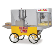 A yellow Merchandising Wagon with four large wheels features a popcorn maker and Cooker Mixer on top, a clear display case showing fresh popcorn, and three containers of Karmel Baby Caramel Corn on the side shelf. Caramel Corn is labeled in red letters.