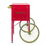 A vintage-style Fun Pop Cart in red, featuring gold lettering that says Popcorn on the side. With easy assembly, two large gold-rimmed wheels, stabilizing legs, and a handle, it perfectly resembles an old-fashioned street vendor’s cart.
