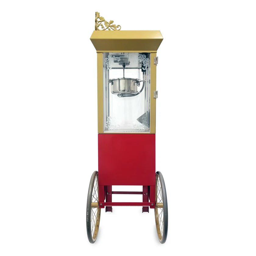 A vintage-style antique deluxe popcorn machine with a gold and red body, ornate trim, glass enclosure, and two large spoked wheels. The popcorn kettle is visible inside, with a small door on the right side for easy access.