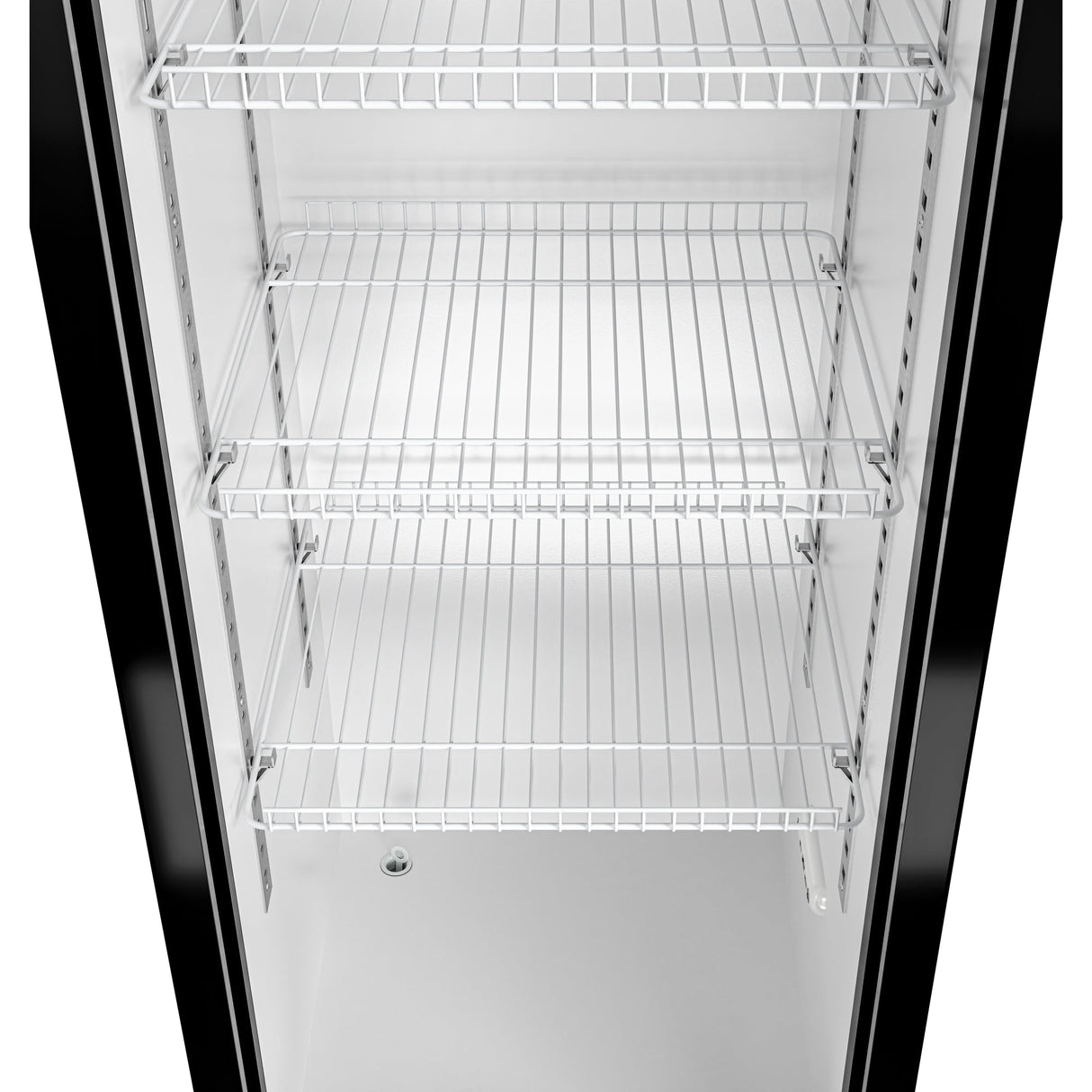 The image shows the interior of an empty commercial merchandiser refrigerator with four wire shelves and a white back panel. The glossy black edges and small circular drain hole on the bottom surface add to the sleek design.