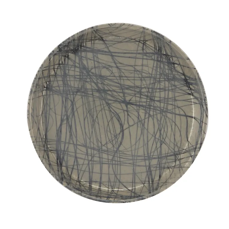 A round fiberglass tray with a beige background features an abstract design of intersecting, dark gray scribble lines, creating a chaotic, modern pattern. Durable and dishwasher safe, the plate is photographed against a plain white background.
