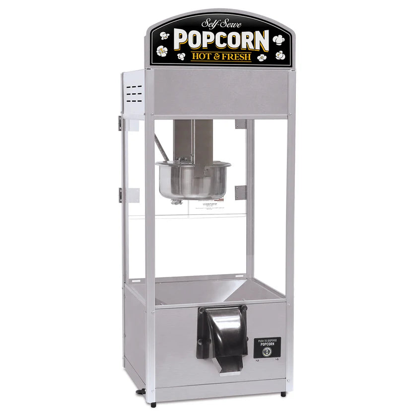 A self-serve popcorn popper with a silver metal frame, clear glass sides, a metal kettle inside, and a dispenser chute at the bottom. This countertop model features a top sign reading “Self Serve POPCORN HOT & FRESH” with popcorn graphics.