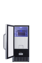 A modern black and stainless steel built-in ice maker with its door open reveals the illuminated ice-making compartment and control panel at the bottom front. The interior features a grid for forming ice and a storage bin below, with the handle on the left side.