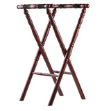 A wooden luggage rack with a rich mahogany finish, featuring turned legs and two thick black slip-proof straps across the top for supporting bags. The rack stands open in an X-shape, with crossbars for stability.