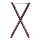 A wooden folding luggage rack with an X-shaped frame, mahogany finish, turned decorative detailing on the legs, and a metal bar at the top for holding a strap or supporting luggage. Slip-proof feet ensure stability. The background is plain white.