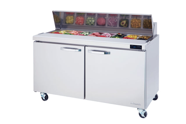 The Blue Air BLPT60-HC refrigerated prep table features two doors and caster wheels. Its open top lid reveals assorted sliced vegetables and ingredients in separate containers, ready for food prep, with a digital temperature display on the right.