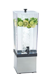 A clear 3-gallon beverage dispenser with a black spigot and stainless steel base, filled with water. Sliced cucumbers, lemon rounds, and mint leaves float at the top, while a central ice core keeps the drink cold. Background is plain white.
