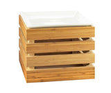 A square, light wood crate riser with horizontal slats, stacked open sides, and a glossy white rectangular plate resting on top. The crate appears sturdy and modern, photographed against a plain white background.