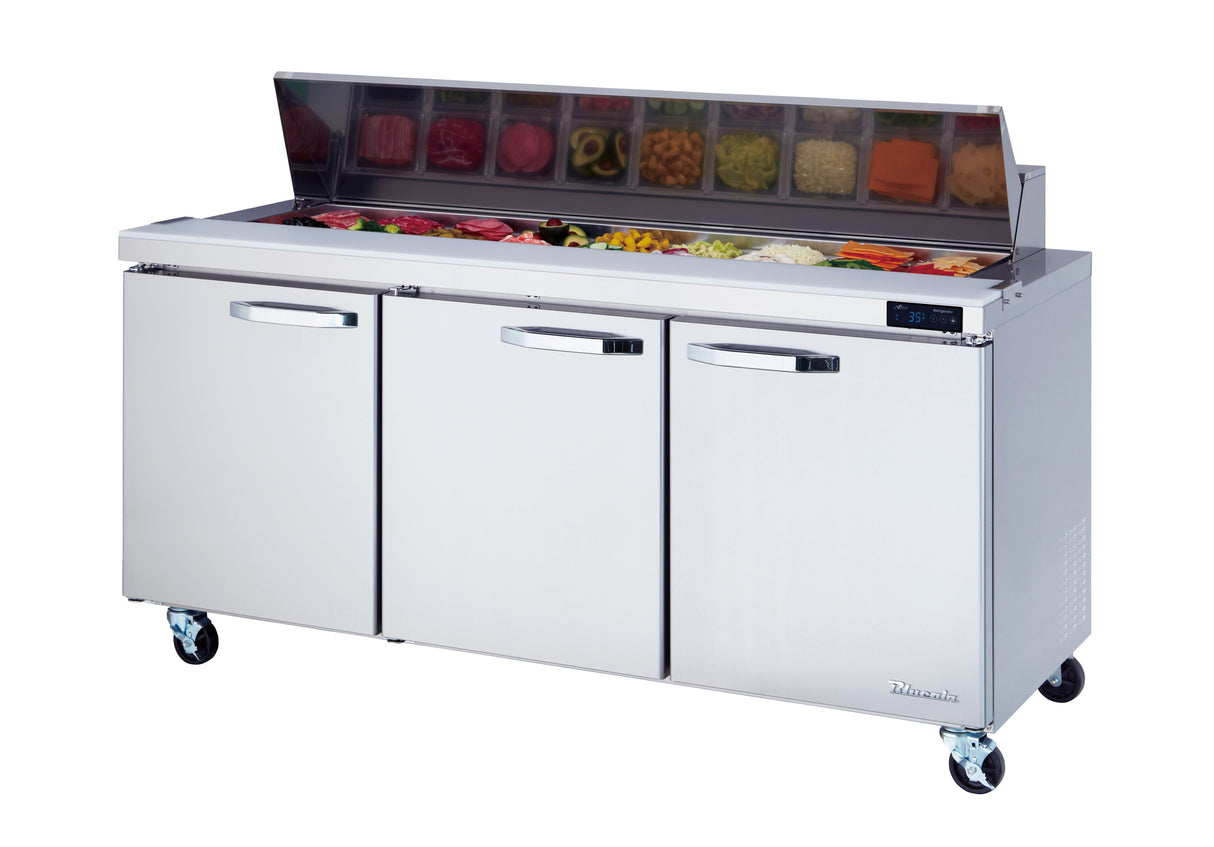 A stainless steel sandwich table with three doors and wheels features sliced vegetables and deli ingredients in open containers, all under a raised glass shield. A digital display is visible on the right side of this sandwich prep table.