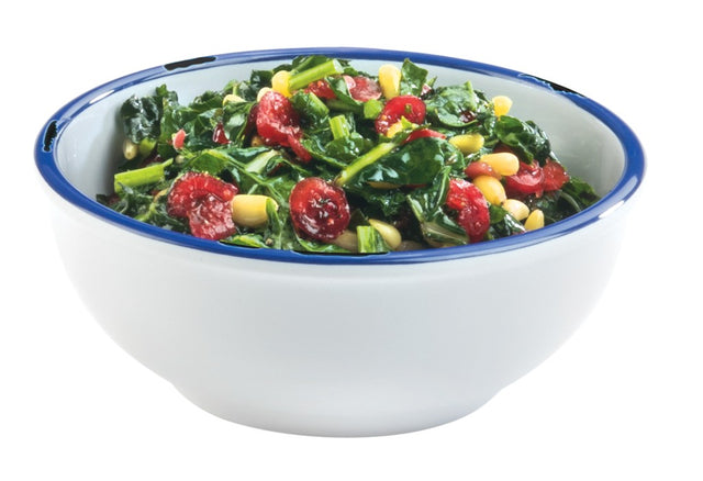 A white melamine bowl with a blue rim is filled with a salad of wilted spinach, yellow corn kernels, and red dried cranberries, all mixed together, against a plain white background.