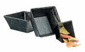 Three connected, angled square bowls in sleek black melamine are arranged from largest to smallest. The smallest bowl holds multicolored tortilla chips—yellow, green, and red—while the other two bowls are empty against a white background.