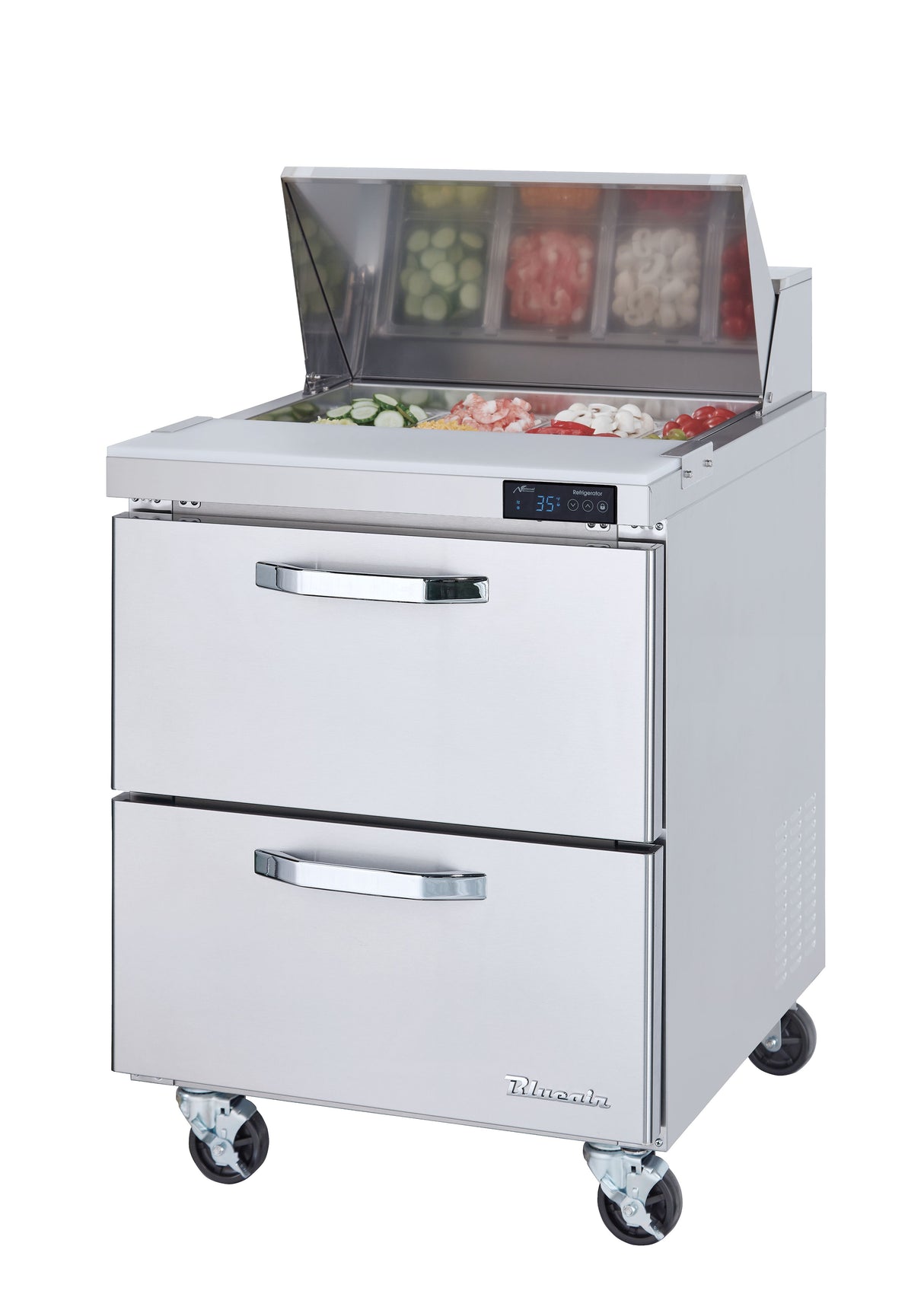 A stainless steel refrigerated prep table with two drawers, four wheels, and a top section holding chopped vegetables in containers under a transparent lid. A digital temperature display is on the front, with the Turbo Air brand on the bottom drawer.