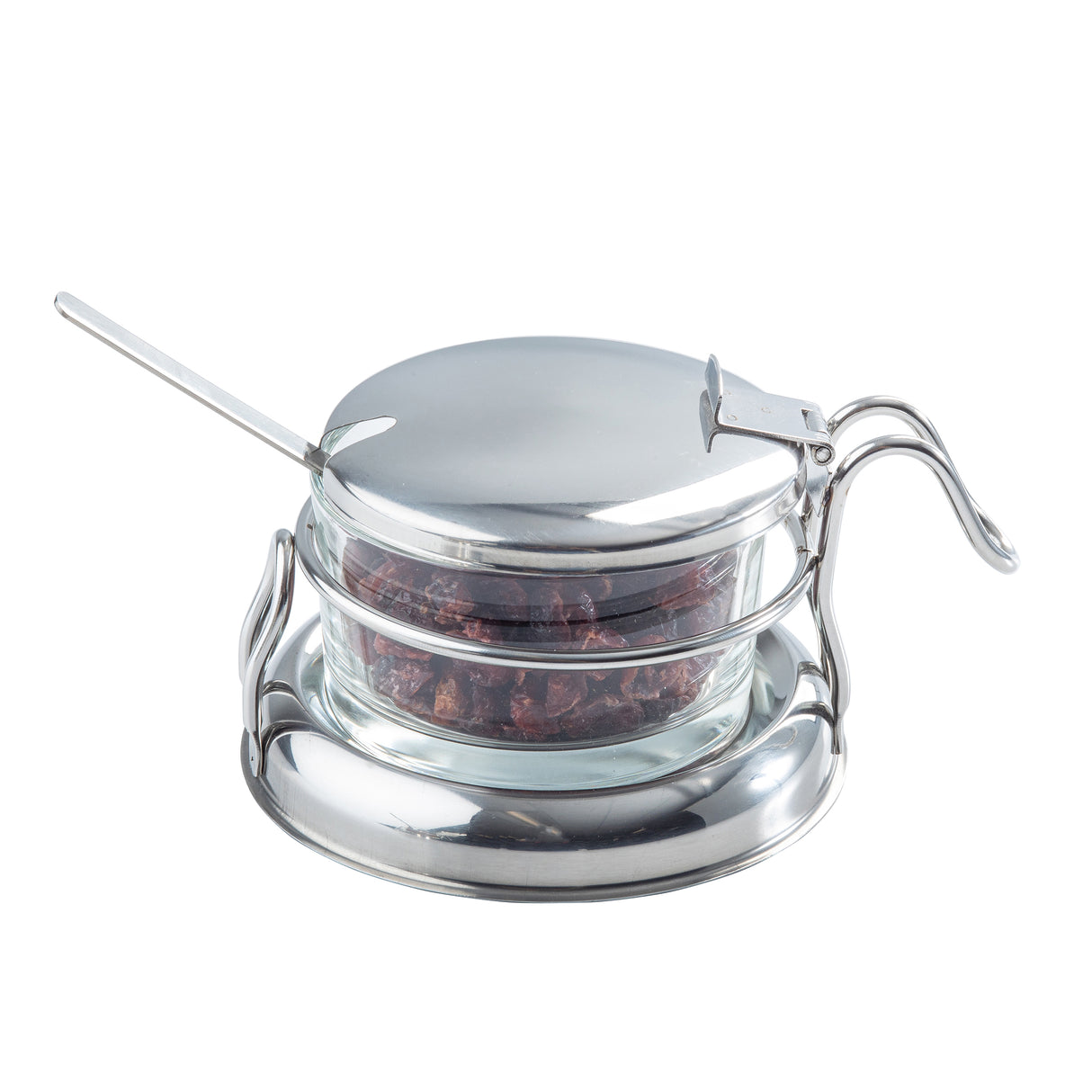 A small glass container filled with dried red chili flakes sits in a shiny metal holder with a lid and curved handle. A metal spoon rests inside, and the dishwasher safe condiment jar set is arranged on a matching round tray against a white background.