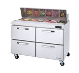 A two-section refrigerated prep table with four pull-out drawers and a chilled top displays sliced vegetables, meats, and toppings. This sandwich prep table features wheels for mobility and a digital temperature display on the front right side.
