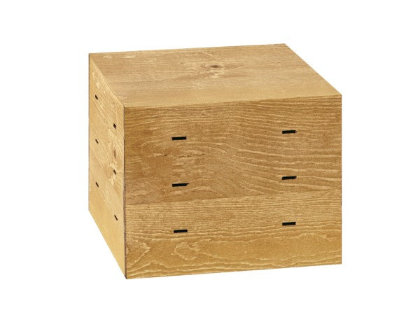 A small, cube-shaped wooden side table with a natural wood grain finish, inspired by rustic pine. Clean edges and subtle rectangular cutouts suggest drawers or storage. The surface appears smooth and unfinished.