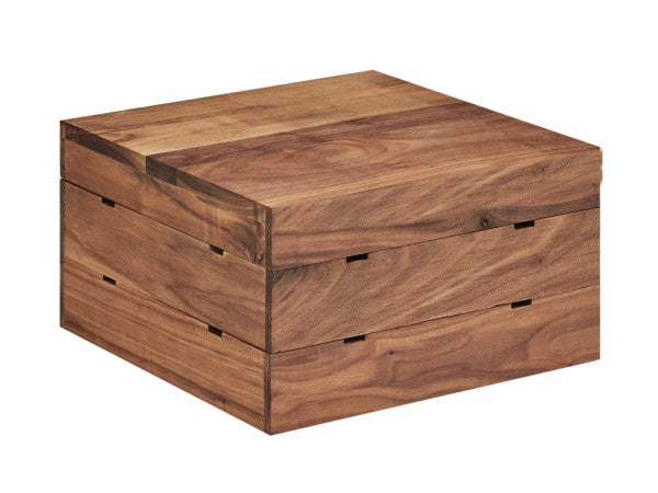 A square walnut wooden box with a smooth, natural finish and visible wood grain. The flat lid and straight sides evoke Mid-Century Crate Riser style, with subtle notches and a seam marking where the lid opens. It rests on a white background.