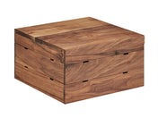 A square walnut wooden box with a smooth, natural finish and visible wood grain. The flat lid and straight sides evoke Mid-Century Crate Riser style, with subtle notches and a seam marking where the lid opens. It rests on a white background.
