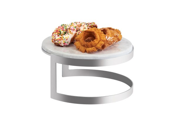 A round, white faux marble melamine serving stand with a modern, curved stainless steel base holds two doughnuts—one with white icing and sprinkles, and one plain and golden brown—against a plain white background.