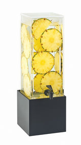 The Midnight Bamboo Beverage Dispenser is a transparent, BPA free, 3 gallon beverage dispenser filled with water and large circular slices of fresh pineapple. It sits on a black rectangular base and features a black spigot for easy pouring.