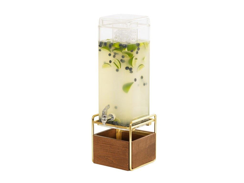 A tall, clear 3 gallon beverage dispenser filled with light yellow liquid, ice, lime slices, and blueberries stands on a gold metal frame with a wooden base and features a spigot for pouring drinks. The background is plain white.