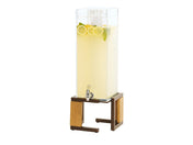 A clear, tall Sierra Beverage Dispenser filled with lemonade, lemon slices, and mint leaves sits on a wooden and metal stand. The dispenser has a spigot at the front and is shown against a white background.