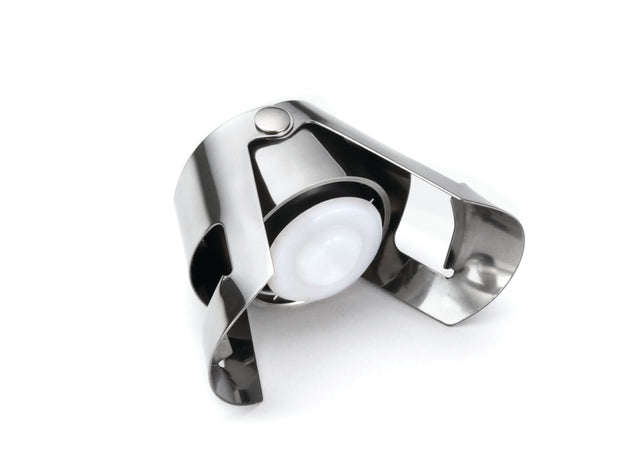 A sleek, durable Champagne Bottle Sealer made of stainless steel with a white plastic seal is shown against a white background. Its hinged arms grip the bottle neck securely and the stopper is dishwasher safe for easy cleaning.