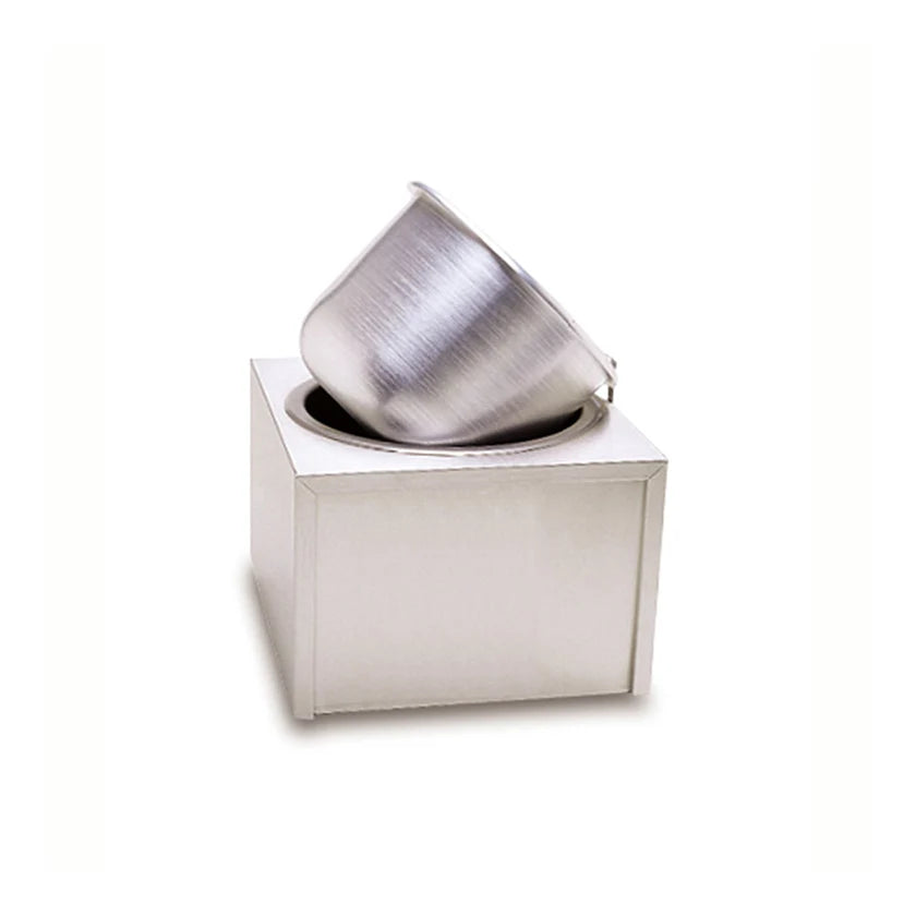 A metallic, brushed-steel insert pot is tilted and partially inserted into a square, white, modern counter-top unit with an opening on top, set against a plain white background. The minimalist design gives a contemporary and sleek appearance.