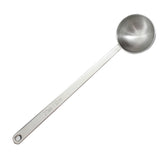 This long handled measuring spoon is crafted from durable stainless steel, featuring a round, deep bowl. The handle displays an engraving of 2 Tbsp / 30 ml and includes a small hole at the end for convenient hanging.