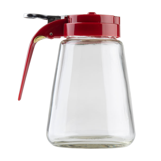 A clear teardrop glass syrup dispenser with a wide base and a red plastic flip-top lid and handle, isolated on a white background. The handle extends downward, and the dishwasher safe container is empty.