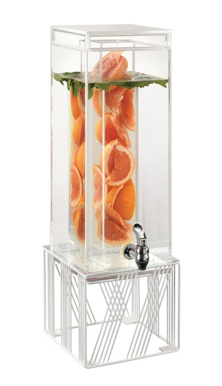 A BPA Free beverage dispenser filled with water and halved oranges, topped with green leaves. This clear, rectangular Infusion Chamber has a silver spigot and sits on a modern white metal stand against a plain white background.