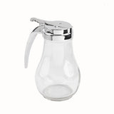 A clear glass TableCraft 414 syrup dispenser with a rounded base and shiny silver metal lid and handle, set against a plain white background. The dispenser features a lever mechanism for pouring and is dishwasher safe for easy cleaning.