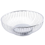 A round, chrome plated Chalet Basket by TableCraft features an open design with vertical wires, an elevated base, and a sleek silver finish. The empty basket is set against a white background.