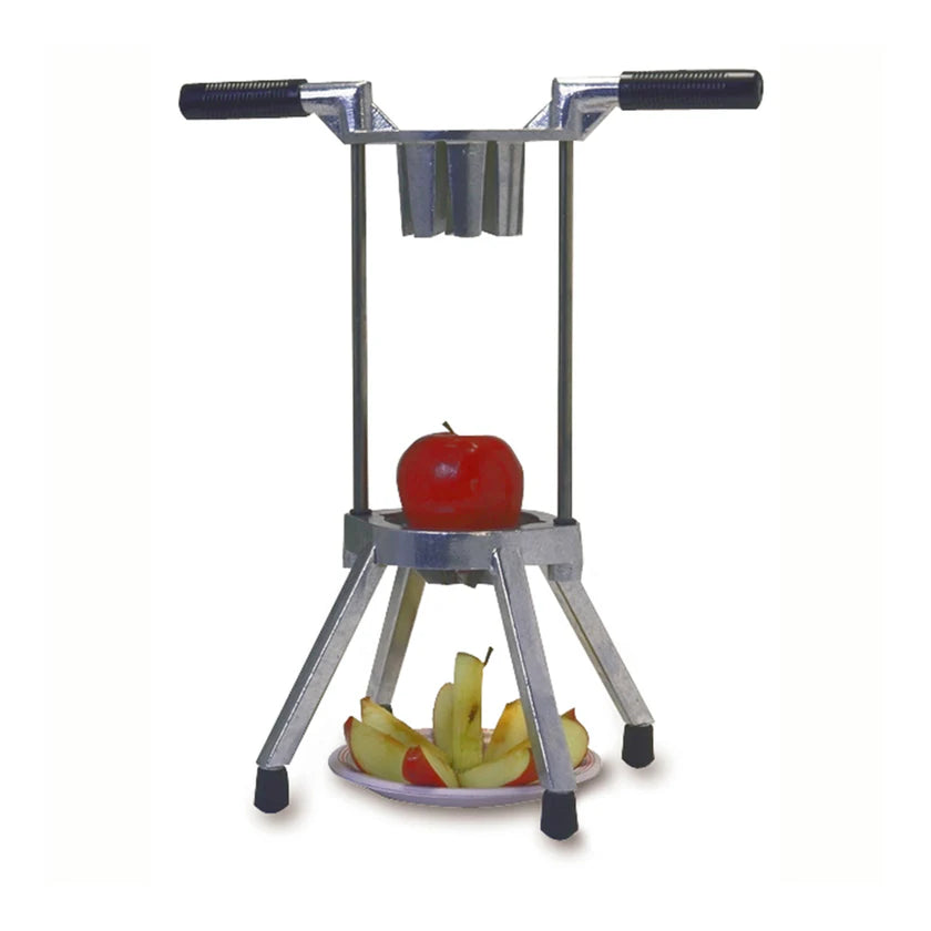 A metal Apple Hacker apple slicer with handles and four legs stands on a surface. A whole red apple is positioned under the blades, while sliced pieces are arranged on a plate beneath it. The background is plain white.
